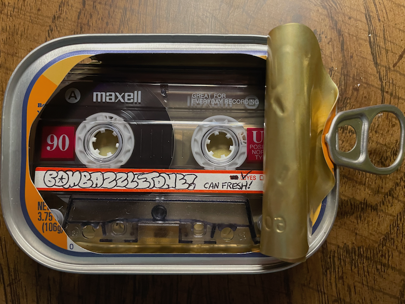 photograph of a cassette tape in a canned fish tin